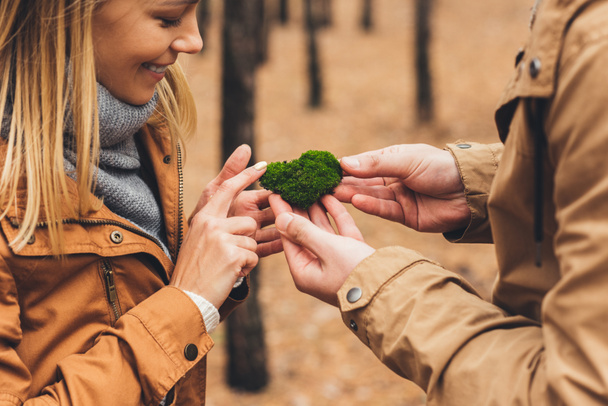 couple touching moss at forest - Фото, изображение
