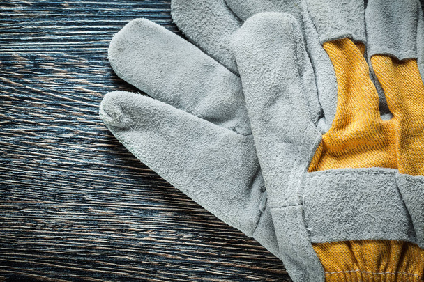 Working gloves on wooden board top view - Φωτογραφία, εικόνα