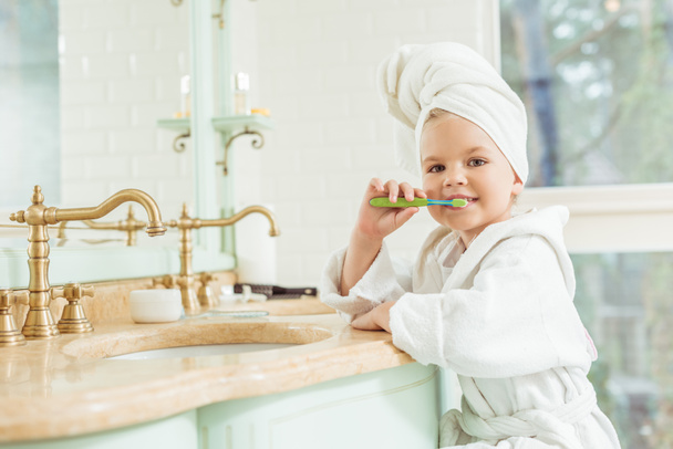 bambino in accappatoio lavarsi i denti
 - Foto, immagini