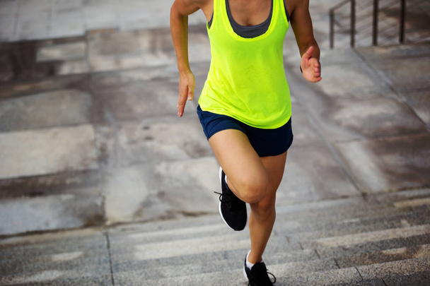 Nuori nainen juoksee portaissa
  - Valokuva, kuva