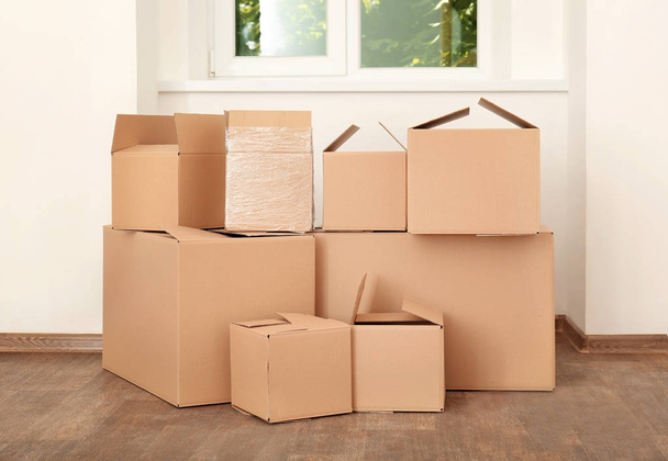 Move house concept. Carton boxes on floor in empty room - Valokuva, kuva