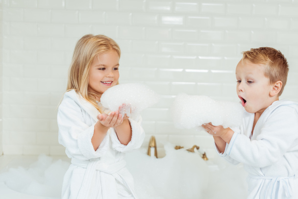 bambini che giocano nella vasca da bagno con schiuma
 - Foto, immagini