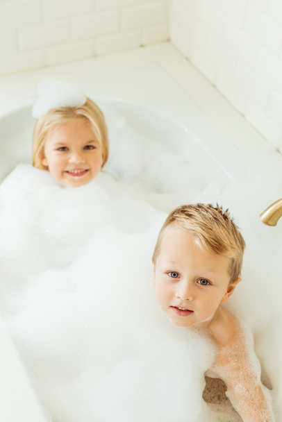 kids playing in bathtub with foam - Photo, Image