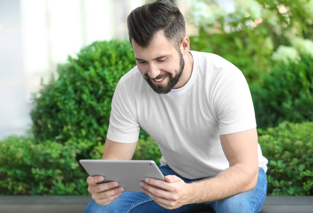 Handsome man with tablet computer outdoors - 写真・画像