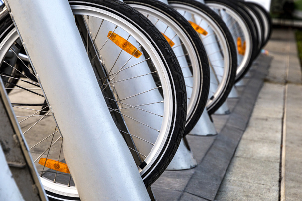 ruedas de bicicleta en alquiler de pie en el aparcamiento
 - Foto, imagen