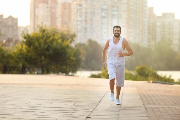 Handsome young man jogging on street - Photo, image