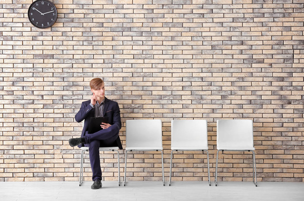 Young man waiting for job interview in hall - Photo, Image