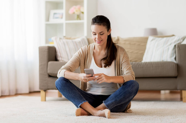 happy woman texting message on smartphone at home - Foto, Bild