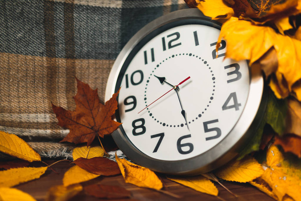 Autumn time. Wall clock among the colorful leaves. - Photo, Image