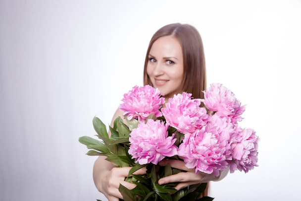 Beautiful girl with peony flowers - Fotó, kép
