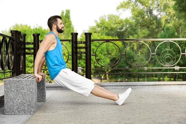 Handsome young man exercising in park - 写真・画像