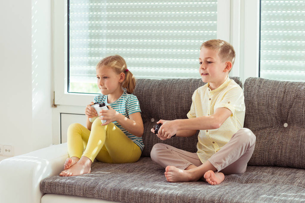 Two happy children playing video games at home - Φωτογραφία, εικόνα