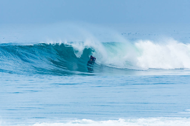Бодібілдер серфінгу океанічної хвилі
 - Фото, зображення