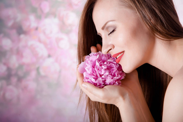 Beautiful girl with peony flowers - Photo, image
