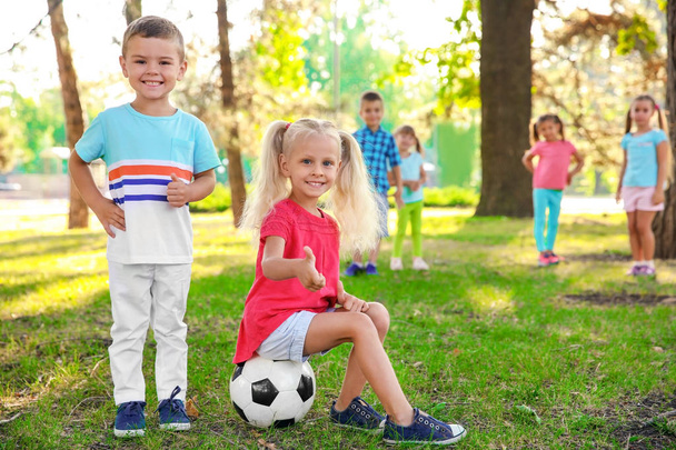 Милі маленькі діти з м'ячем в парку
 - Фото, зображення