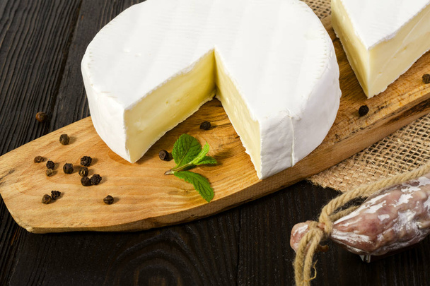 Kerek Camembert sajt szeletelt, a fa tábla és fuet-Figueres - Fotó, kép