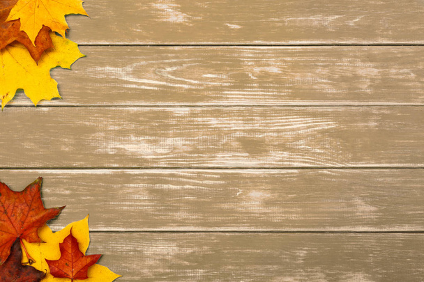 Кленове листя лежить на коричневому дерев'яному фоні. концепція осені
. - Фото, зображення