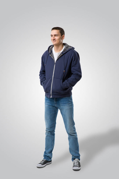 young casual man with hands in pockets looking away from the camera to his side. Isolate - Photo, Image