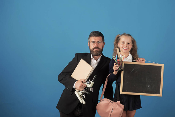 Education and back to school concept. Teacher and schoolgirl - Фото, изображение