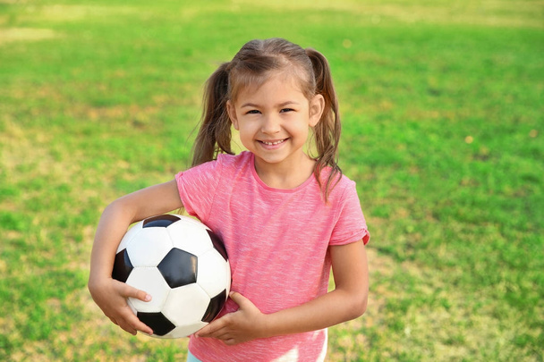 Cute little girl holding ball outdoors - 写真・画像