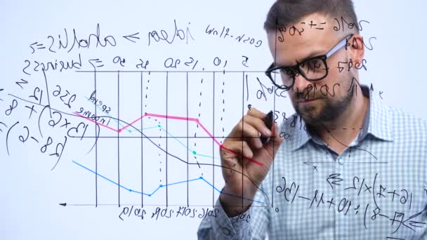 El hombre dibuja varias tablas de crecimiento, calculando las perspectivas de éxito en una moderna oficina de vidrio
 - Metraje, vídeo