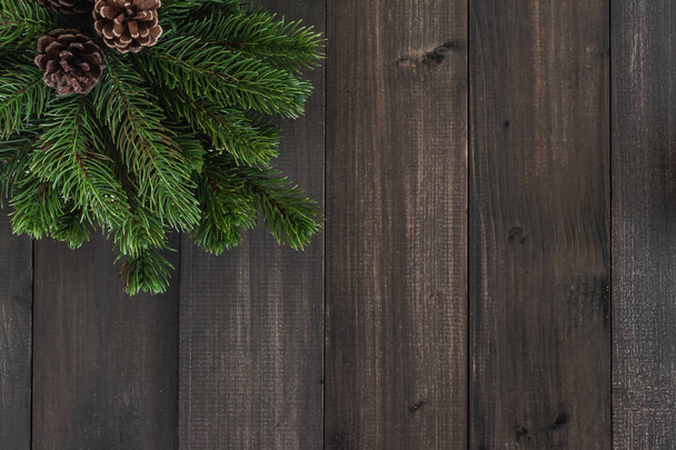 Christmas fir tree branches and pine on dark rustic wooden backg - Foto, imagen