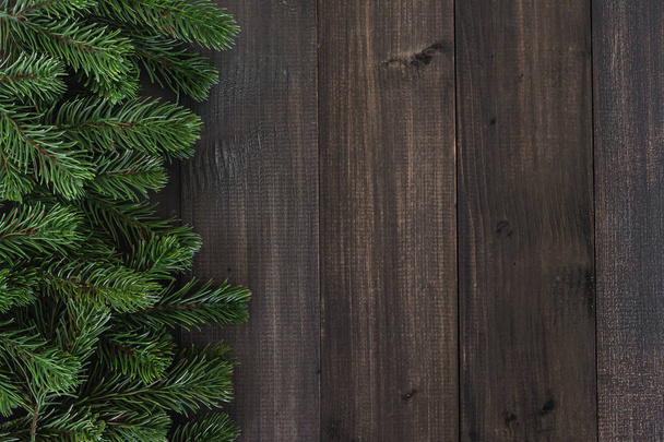 Christmas fir tree branches on dark rustic wooden background wit - Fotografie, Obrázek