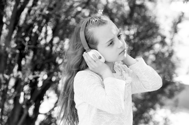 Cute little girl enjoying music using headphones - Foto, immagini