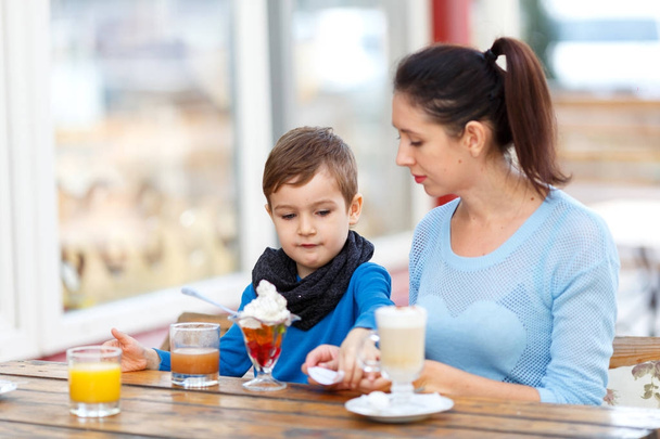 Mom with a child in a cafe eating dessert - Foto, Bild