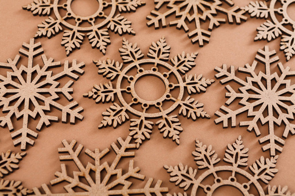 ベージュ色の背景に木製の雪片のパターン - 写真・画像