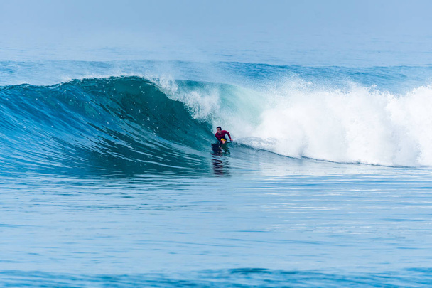 Бодібілдер серфінгу океанічної хвилі
 - Фото, зображення