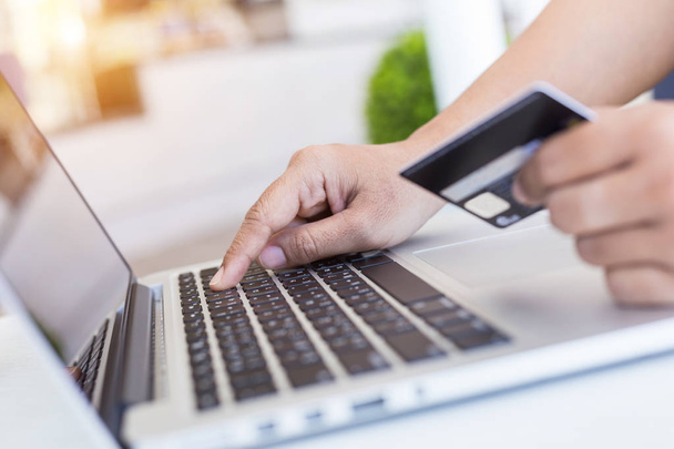 Woman hands holding credit card in front of laptop on the desk.  - Fotoğraf, Görsel