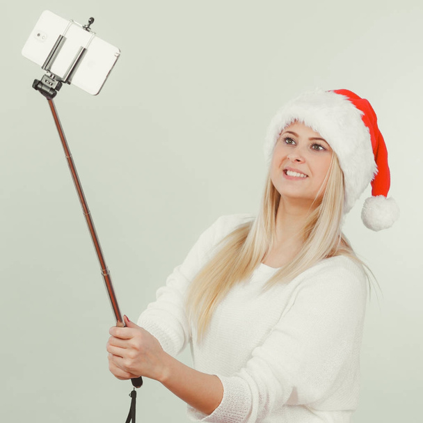 Woman in santa hat taking selfie - Φωτογραφία, εικόνα