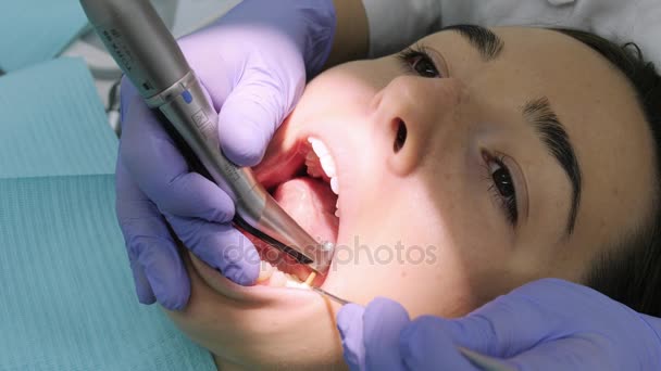 クライアントの下の歯を磨く女性歯科医. - 映像、動画