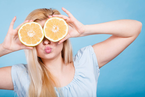 Girl covering her eyes with grapefruits - Photo, image