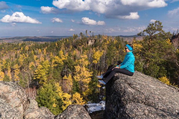 The hiker girl is siting on the edge of a cliff - Foto, Bild