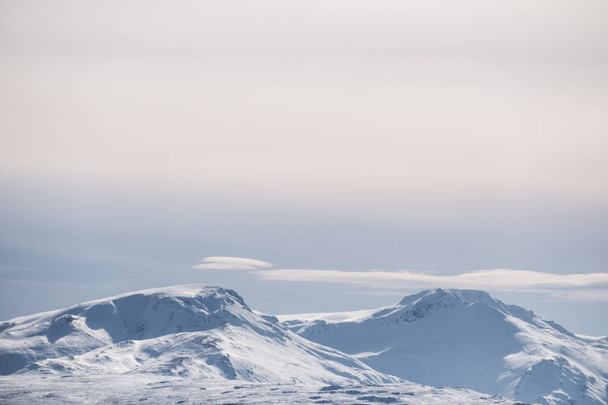 Pic de montagne enneigé et ciel bleu avec nuages blancs en hiver, paysage hivernal en Islande
 - Photo, image