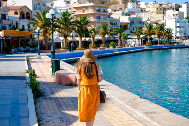 Young girl in a straw hat walking along the quay - Photo, Image