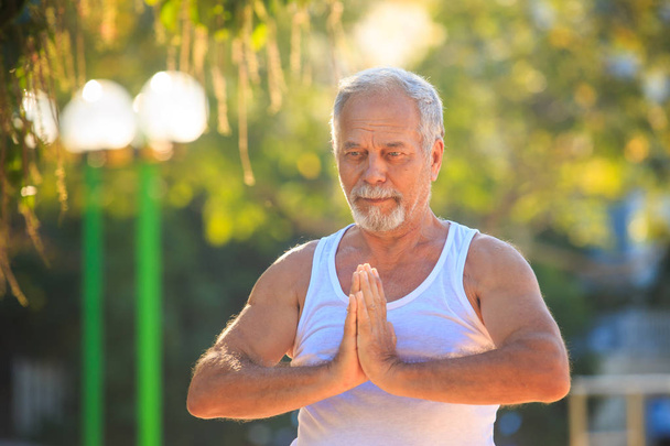 Man Shows Yoga Pose in Park - Foto, imagen