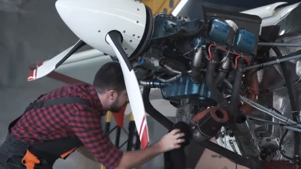 Чоловік чистить авіаційний двигун в ангарі
 - Кадри, відео