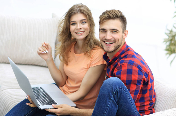 pair students with a laptop sitting on sofa - Foto, imagen