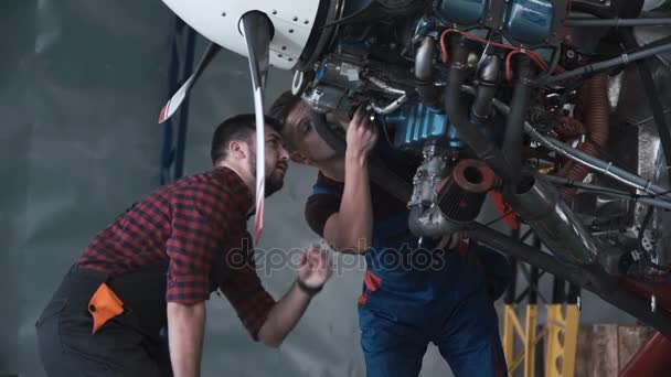 Two mechanics working on a small aircraft - Footage, Video