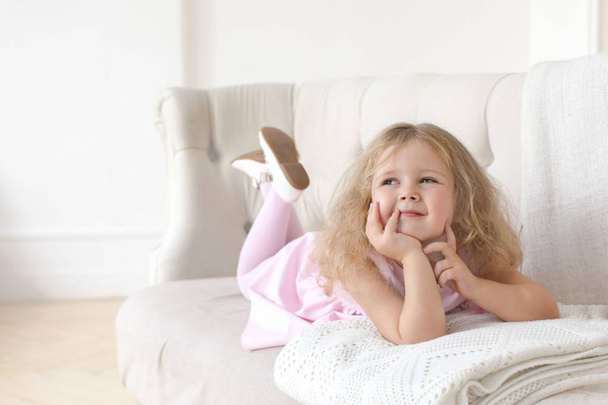 Bájos kis lány pózol a kanapé - Fotó, kép