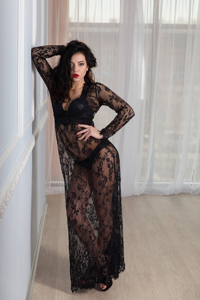 sexy young brunette woman in black lace dress. Beautiful girl with attractive body. - 写真・画像