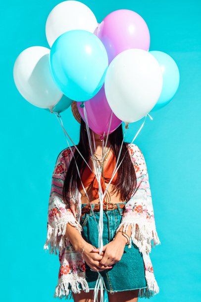 Hippie woman covering face with balloons  - 写真・画像