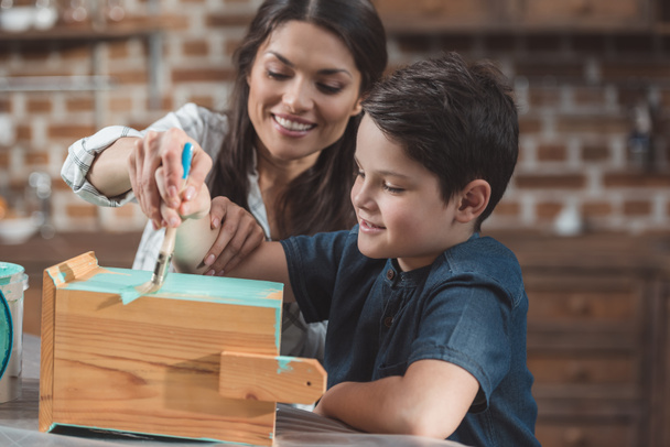 Mother and son painting birdhouse - Photo, Image