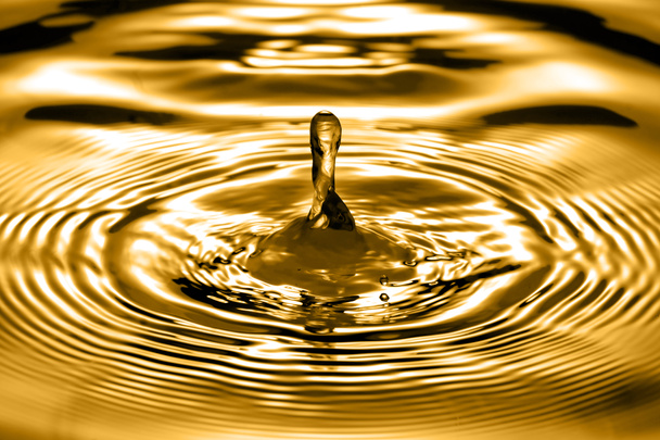Drops of liquid gold close up with beautiful wave - Photo, Image
