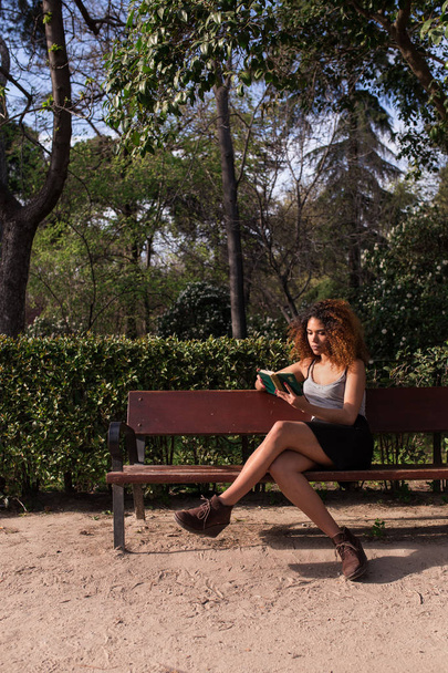 afro mujer leyendo un libro en un banco
 - Foto, Imagen