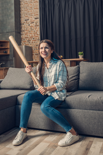 Woman with bat watching baseball on tv - Fotoğraf, Görsel