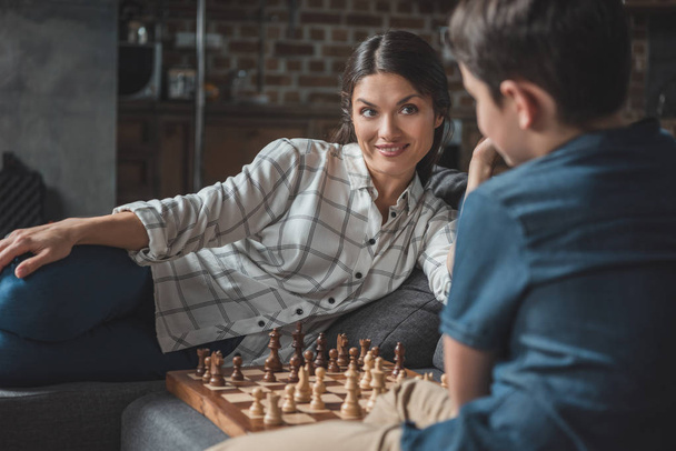 Mãe e menino jogando xadrez
 - Foto, Imagem